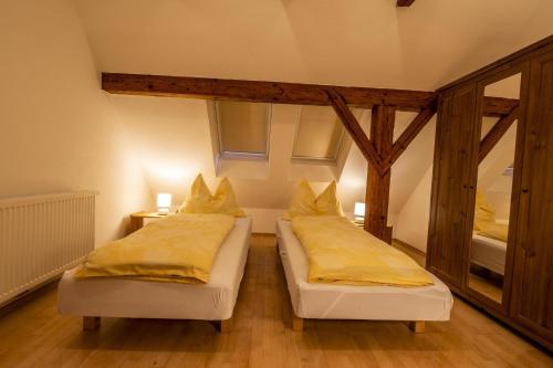 two beds in a room with yellow pillows at Ferienhof Pacher in Spital am Pyhrn