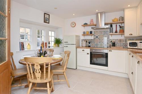 a kitchen with a table and chairs in a kitchen at Briar Cottage in Kirk Ireton