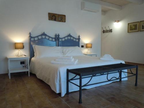 a bedroom with a large bed with a blue headboard at Antica Cascina Pilo in Monchiero