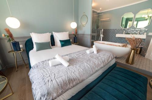 une chambre avec un grand lit et une baignoire dans l'établissement The Parisian Blue Eiffel Tower, à Paris