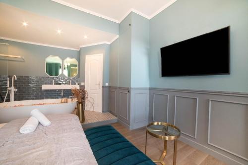 La salle de bains est pourvue d'une baignoire et d'une télévision murale. dans l'établissement The Parisian Blue Eiffel Tower, à Paris