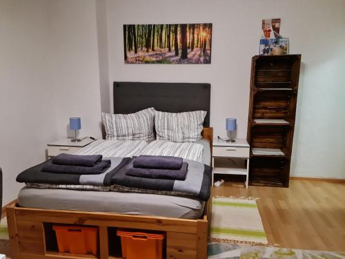 um quarto com uma cama com duas mesas e uma imagem na parede em Ferienwohnung BerGlück em Inzell
