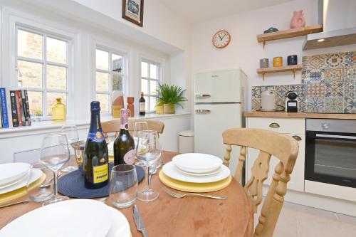 a kitchen with a wooden table with wine bottles at Briar Cottage in Kirk Ireton