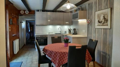 cocina con mesa y mantel rojo en Gite Gabrielle en Blaesheim