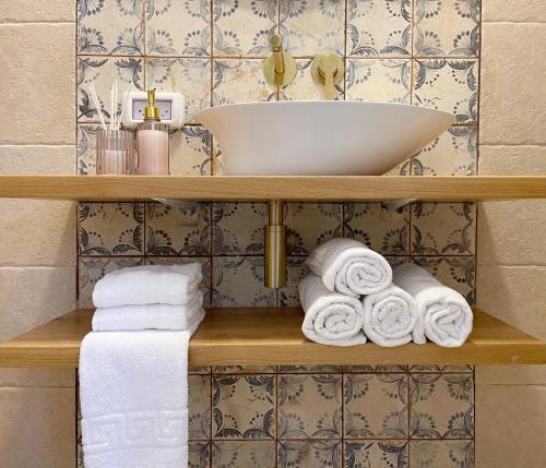 a bathroom with a sink and towels on a shelf at Bar Bakfar in Sharona