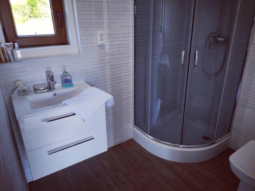 a white bathroom with a shower and a sink at Nad Rozlewiskiem Rzeszów in Rzeszów