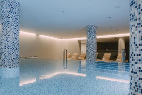 a large swimming pool with chairs in a building at Nektar 88 in Vrnjačka Banja