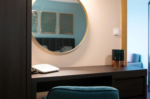 a mirror on a desk with a blue chair at Hotel Zlatý Býk in Rimavská Sobota
