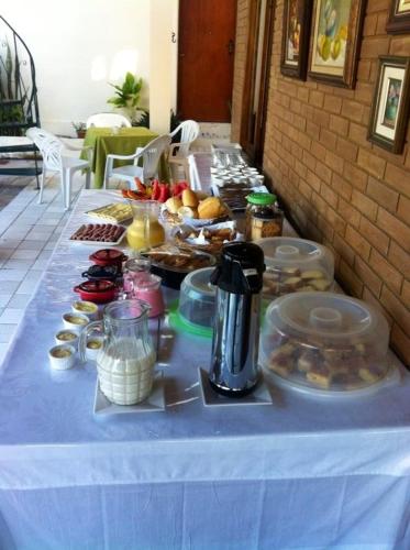 a table with a blue table cloth with food on it at Pousada Villa Joia in Barra de São Miguel