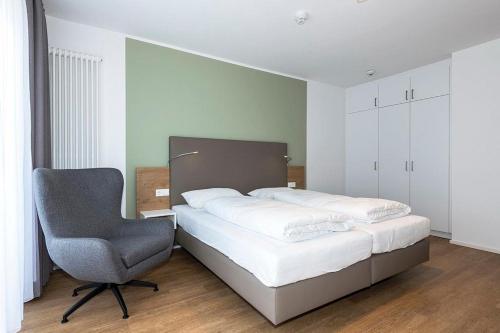 a bedroom with a bed and a chair at Apartmentvilla Anna See Apartmentvilla Anna See 1-17 in Langeoog
