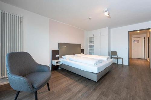 a bedroom with a bed and a chair at Apartmentvilla Anna See Apartmentvilla Anna See 2-12 in Langeoog
