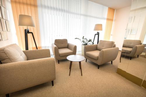a waiting room with chairs and chairs and a table at Hotel Zlatý Býk in Rimavská Sobota