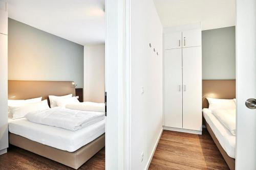 ein Schlafzimmer mit zwei Betten und einem Kleiderschrank in der Unterkunft Deichhäuser Anna Küste Deichhäuser Anna Küste 4-13 in Bensersiel