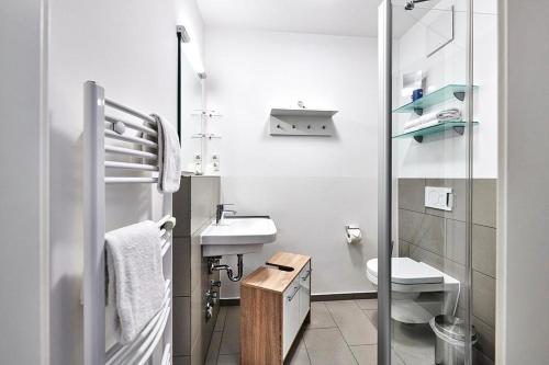 ein weißes Badezimmer mit Waschbecken und Toilette in der Unterkunft Deichhäuser Anna Küste Deichhäuser Anna Küste 4-13 in Bensersiel