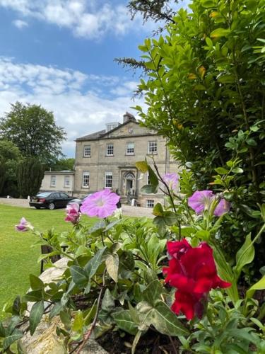 a house with a bunch of flowers in front of it at Limefield Mansion House in Livingston