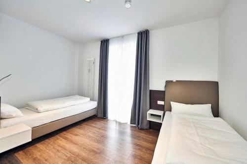 ein Schlafzimmer mit zwei Betten und einem Fenster in der Unterkunft Deichhäuser Anna Küste Deichhäuser Anna Küste 4-14 in Bensersiel