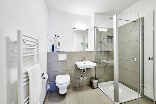 ein Badezimmer mit Dusche, Toilette und Waschbecken in der Unterkunft Deichhäuser Anna Küste Deichhäuser Anna Küste 4-14 in Bensersiel