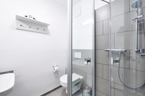 ein Badezimmer mit Toilette und Glasdusche in der Unterkunft Deichhäuser Anna Küste Deichhäuser Anna Küste 4-23 in Bensersiel