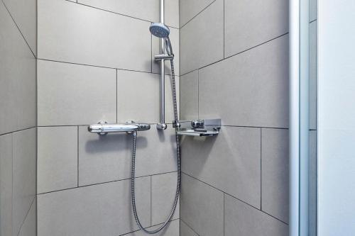 eine Dusche mit Duschkopf an der Wand in der Unterkunft Deichhäuser Anna Küste Deichhäuser Anna Küste 4-31 in Bensersiel