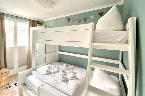 a white bunk bed with white towels on it at Dünenschloss Dünenschloss 2-16 in Kühlungsborn