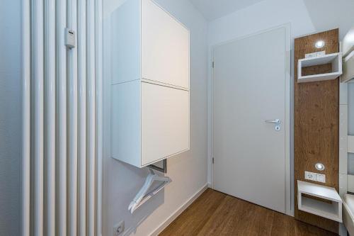 ein Badezimmer mit einem weißen Schrank und einer Tür in der Unterkunft Deichhäuser Anna Küste Deichhäuser Anna Küste 8-20 in Bensersiel