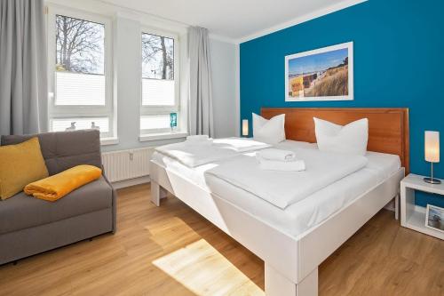 a bedroom with a large white bed and a couch at Strand-Park Strand-Park 204 in Heringsdorf