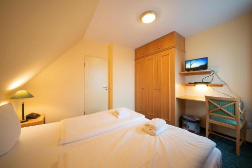 um quarto com uma cama, um armário e uma televisão em Hus Inselkieker Hus Inselkieker 216 em Schillig