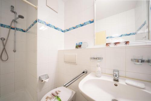 uma casa de banho branca com um WC e um lavatório em Hus Inselkieker Hus Inselkieker 216 em Schillig