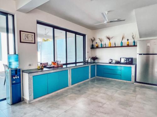 a kitchen with blue cabinets and a large window at Villa Lagoonscape in Negombo