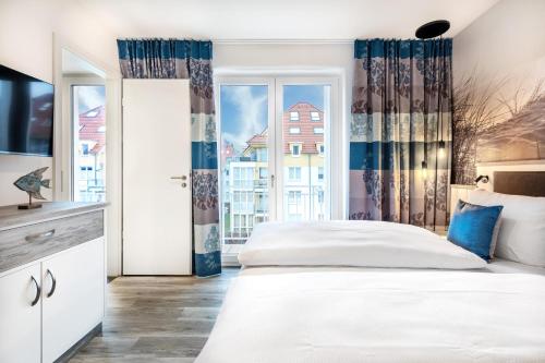 ein Schlafzimmer mit großem Bett und Fenster in der Unterkunft Apartmentanlage Meerblickvilla Apartmentanlage Meerblickvilla 2-18 in Großenbrode