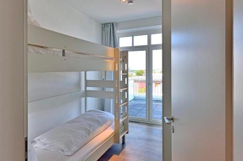 1 dormitorio con literas y puerta a un balcón en Aparthotel Anna Düne Aparthotel Anna Düne 1-18, en Wangerooge