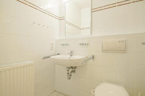 ein weißes Bad mit einem Waschbecken und einem WC in der Unterkunft Hus Inselkieker Hus Inselkieker 219 in Schillig