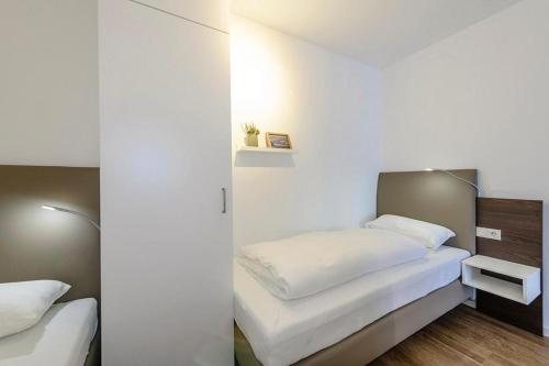 a bedroom with two beds with white sheets at Deichhäuser Anna Küste Deichhäuser Anna Küste 1-21 in Bensersiel