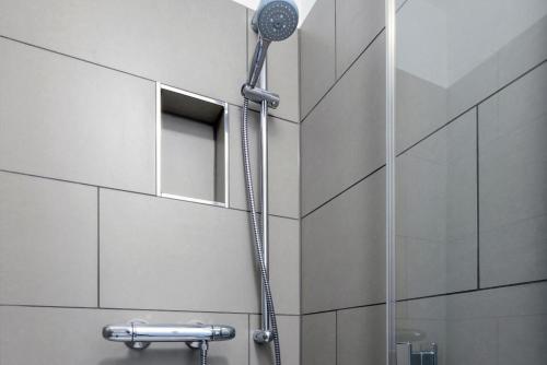a shower with a shower head in a bathroom at Deichhäuser Anna Küste Deichhäuser Anna Küste 1-21 in Bensersiel