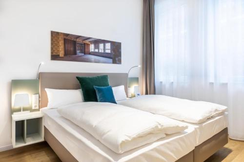 ein Schlafzimmer mit zwei Betten mit weißer Bettwäsche in der Unterkunft Ferienapartments am Krusespeicher Ferienapartments am Krusespeicher 3-30 in Wismar