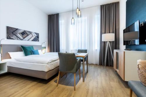 a hotel room with a bed and a desk with a chair at Ferienapartments am Krusespeicher Ferienapartments am Krusespeicher 3-33 in Wismar