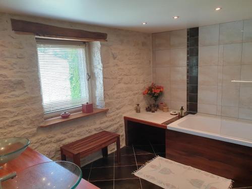 a bathroom with a bath tub and a sink at Les Écuries in Frontenay-Rohan-Rohan