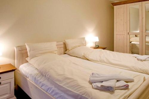 - un lit blanc avec des serviettes dans la chambre dans l'établissement Urlaubsräume am Meer Urlaubsräume am Meer 1-3, à Fulgen