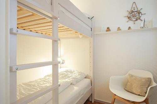 een slaapkamer met een stapelbed en een stoel bij Haus Panorama Haus Panorama 12 in Wangerooge