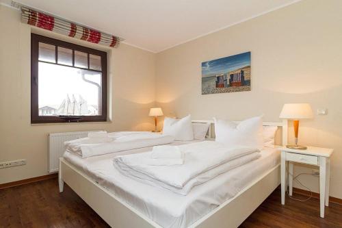 2 weiße Betten in einem Zimmer mit Fenster in der Unterkunft Urlaubsräume am Meer Urlaubsräume am Meer 3-14 in Fulgen