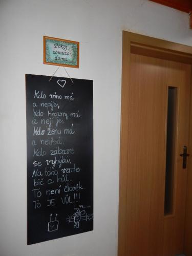 a chalkboard with writing on a wall next to a door at Chalúpka u Fulov in Bziny