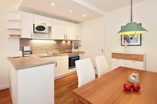 eine Küche mit einem Holztisch und weißen Schränken in der Unterkunft Strand-Park Strand-Park 304 in Heringsdorf