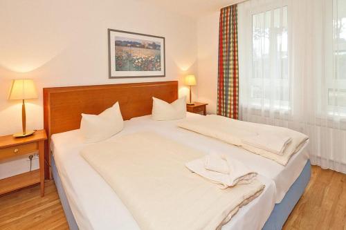 ein großes weißes Bett in einem Zimmer mit Fenster in der Unterkunft Strand-Park Strand-Park 304 in Heringsdorf