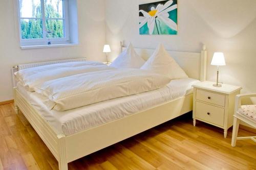 a white bed with white sheets and pillows in a bedroom at Strand-Park Strand-Park V01 in Heringsdorf