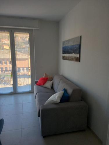 uma sala de estar com um sofá e uma janela em Appartamento Pleiadi em Finale Ligure