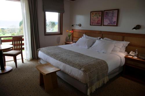 a hotel room with a large bed and a window at Hotel Termas Puyehue Wellness & Spa Resort in Puyehue