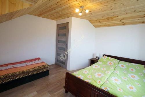 sypialnia z łóżkiem i drewnianym sufitem w obiekcie Domek na skraju lasu w mieście Dąbrowa Górna