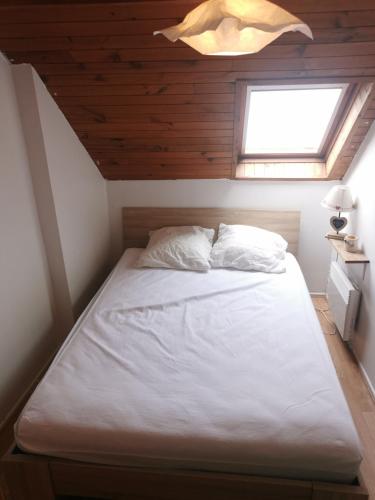 un lit dans une petite pièce avec une fenêtre dans l'établissement Le petit Chalet Luchonnais, à Luchon