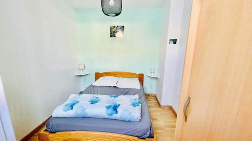 Habitación pequeña con cama con sábanas azules. en Résidence Le mont Dore 2 étoiles, en Le Mont-Dore