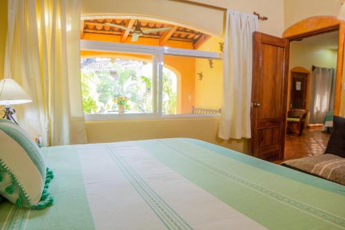a bedroom with a bed and a window at Bungalows Jaqueline in Sayulita